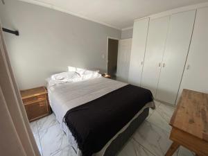 a bedroom with a bed and a wooden table at Spanish Villa- Pet Friendly in Cape Town