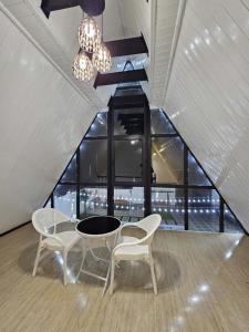 a table and chairs in a room with a large window at Dreamvilla aframe in Gabala