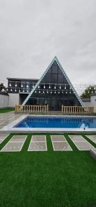 a building with a swimming pool and green grass at Dreamvilla aframe in Gabala