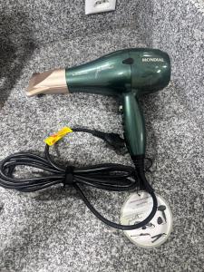 a green hair dryer on a counter with a cord at La Vita hospedaria studio verde in Nova Veneza