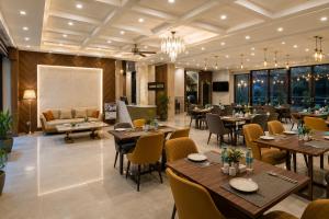 a restaurant with tables and chairs and a couch at Hotel Aroma Suites Delhi - With Free Airport Drop in New Delhi