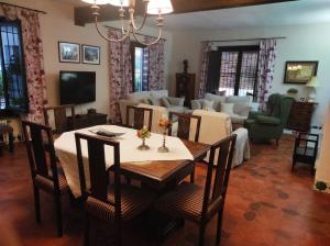 a dining room with a table and a living room at Casería El Albercón in Mancha Real
