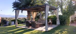 a gazebo with chairs and a table on a lawn at Casería El Albercón in Mancha Real