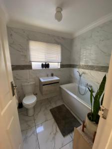 a bathroom with a toilet and a tub and a sink at Spanish Villa- Pet Friendly in Cape Town +9 photos
