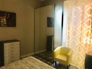 a bedroom with a chair and a dresser and a mirror at CASA Di ANNA 2 in Terracina