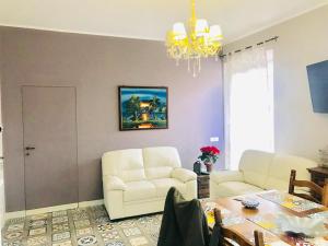 a living room with two white chairs and a table at CASA Di ANNA 2 in Terracina