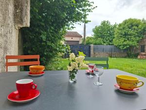 a table with two cups and saucers and flowers on it at Maison de campagne - Granges sur Lot in Granges-sur-Lot +8 photos