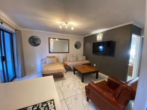 a living room with a couch and a table at Spanish Villa- Pet Friendly in Cape Town