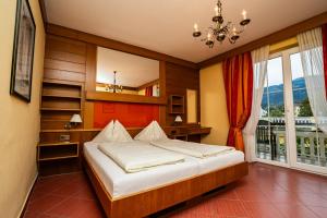 a bedroom with a bed and a window at Seehotel Steiner in Seeboden +43 photos