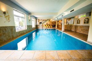 a large swimming pool with blue tile in a building at Seehotel Steiner in Seeboden
