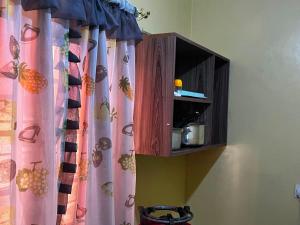 a wooden cabinet with a curtain in a room at Petalluxe k24 in Narok