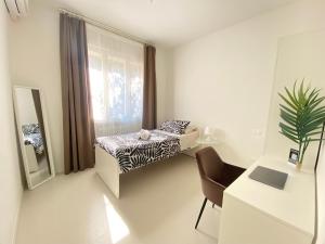 a bedroom with a bed and a desk and a mirror at Urban Suite- Holiday Rooms in Padova