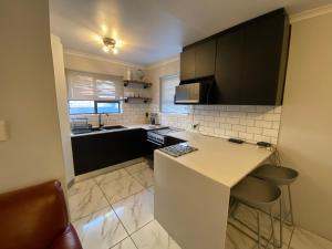a kitchen with a white counter top and a sink at Spanish Villa- Pet Friendly in Cape Town