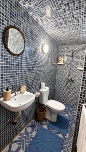 a bathroom with a sink and a toilet and a mirror at Riad Fes Layan in Fez