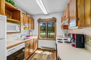 a kitchen with wooden cabinets and a sink at Chipmunk in Clark +23 photos