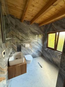 a bathroom with a sink and a toilet at Rosi peak Guesthouse in Valbonë