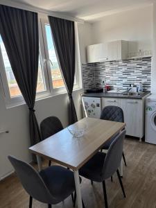 a kitchen and dining room with a wooden table and chairs at Fenix apartman in Zaječar