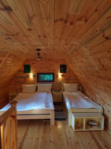 a bedroom with two beds in a wooden cabin at Utopija Cabin by Vilovi Botić in Nova Varoš