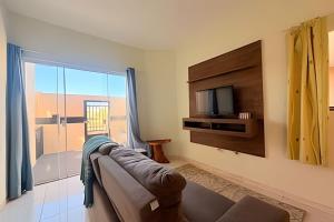 a living room with a couch and a tv and a window at Completa e próxima ao Acqualinda in Andradina