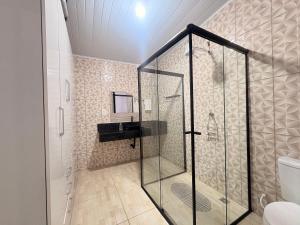 a bathroom with a shower with a sink and a shower stall at Completa e próxima ao Acqualinda in Andradina +43 photos