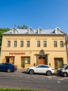 a yellow building with cars parked in front of it at Apartmány Tonny in Jáchymov