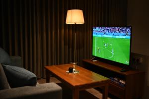 a living room with a tv and a coffee table with a television at RuKu Villa Pussellawa in Pussellawa +11 photos