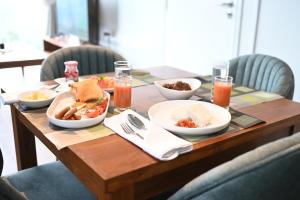 a wooden table with plates of food on it at RuKu Villa Pussellawa in Pussellawa