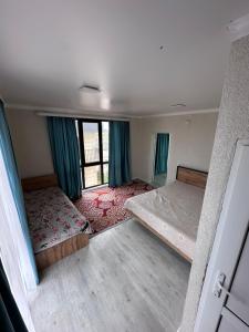 an empty room with two beds and a window at Гостевой дом Бакай in Imeni Kirova