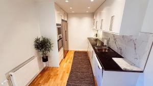 a kitchen with white cabinets and a black counter top at Villa lugn och ro in Gustavsberg