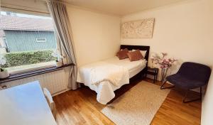 a small bedroom with a bed and a window at Villa lugn och ro in Gustavsberg