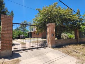 a wrought iron gate with a brick pillar at Chalet ARMONIA in La Falda