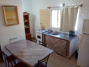 a kitchen with a table and a sink and a stove at Chalet ARMONIA in La Falda