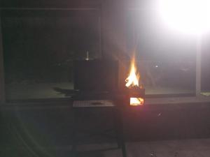 a fire is burning in a room with a window at Chalet ARMONIA in La Falda
