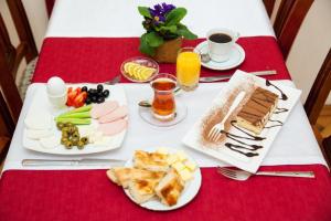 a table with plates of food on a red table at Azcot Nizami Hotel in Baku