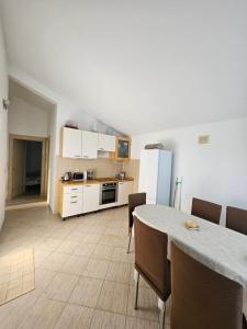 a kitchen with a table and chairs and a refrigerator at Gabi in Ðuraševići