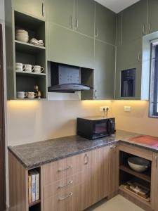 a kitchen with a counter top with a microwave at Villa Clasic Comfort in Navalur