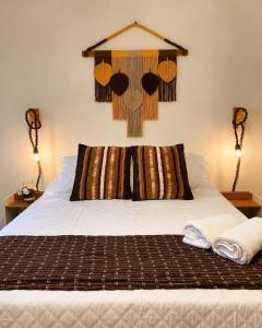 a bed with a pillow on top of it at Pousada Narval Buzios in Búzios