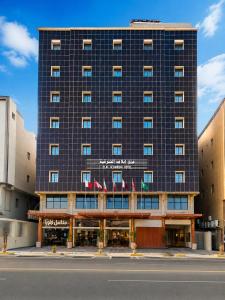 a hotel building with flags in front of it at Elaf Al Sharqyah Hotel -Alaziziah فندق ايلاف الشرقية العزيزية in Al Khobar
