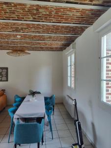 a dining room with a table and blue chairs at La Clé des Vignes 3 in Roye +4 photos