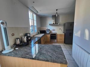 a large kitchen with a counter top in a room at La Clé des Vignes 3 in Roye