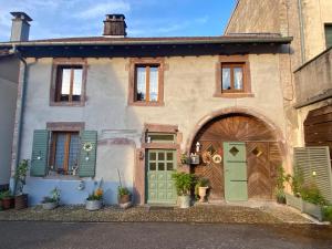 an old house with green doors and windows at Le temps d'une pause bed and breakfast in Servance
