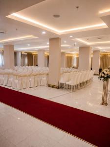 a banquet hall with rows of white chairs and tables at Elaf Al Sharqyah Hotel -Alaziziah فندق ايلاف الشرقية العزيزية in Al Khobar