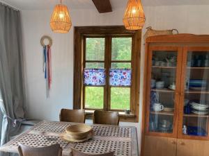 a dining room with a table and a window at Good Chata Leśna Polana in Dobry Las