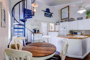 a kitchen and dining room with a table and a spiral staircase at Driftwood Villa - 269 in Edisto Island