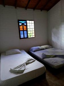 two beds in a room with a window at Cabaña Bamel in San Antero