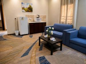 a living room with two blue chairs and a coffee table at Elaf Al Sharqyah Hotel -Alaziziah فندق ايلاف الشرقية العزيزية in Al Khobar