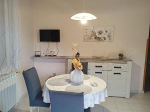 a dining room table with a vase and two chairs at Apartments Smolica in Labin