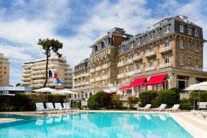 a hotel with a large swimming pool in front of a building at Hôtel Barrière Le Royal La Baule in La Baule