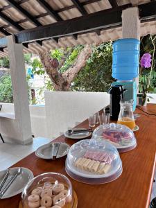 a wooden table with plates of food on it at Pousada Narval Buzios in Búzios