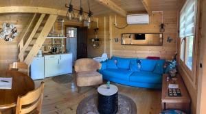 a living room with a blue couch and a kitchen at Woodhouse Maja in Virpazar